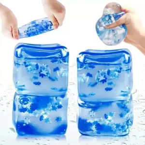 Primer plano del juguete antiestrés cuadrado azul transparente con copos de nieve dentro.