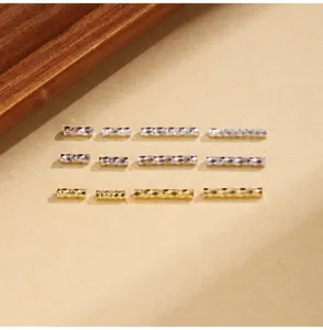 Close-up detail of silver and gold faceted straight tube spacer beads for DIY jewelry making.