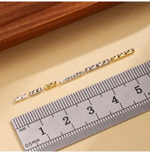 Close-up detail of faceted silver and gold spacer tubes with sparkling laser texture for DIY.