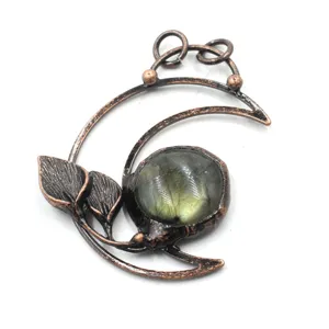 Close-up of vintage copper crescent moon pendant with natural labradorite stone detail.