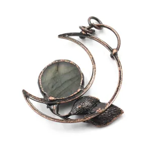 Detailed view of vintage copper wire wrapped crescent moon crystal pendant jewelry accessory.