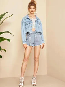 Detailopname van lichtblauwe dames denim jas met rafelige zoom en trendy used-look details.