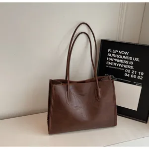 Brown PU leather tote bag detail, featuring durable double top handles and spacious daily capacity.