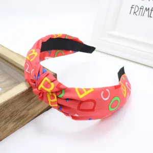 Serre-tête en tissu large rouge avec imprimé alphabet coloré, accessoire élégant noué.