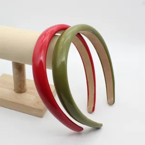 Close-up detail of wide PU leather padded headbands in red and green, chic hair accessories.