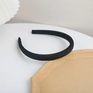 Detailed view of a classic minimalist black padded headband, chic everyday accessory.