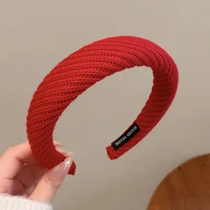 Accessoire serre-tête large tricoté rouge détail gros plan montrant une texture douce.