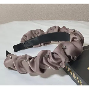 Detailed view of the vintage satin rhinestone headband featuring elegant pleated design.
