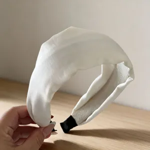 Detail view of a white satin wide headband, elegant hair accessory for women daily wear.