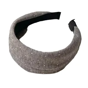 Closeup of grey knit headband featuring subtle white polka dots and neat black inner edge trim.