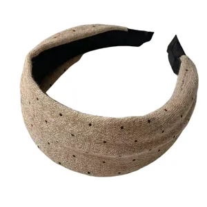 Detailed view of the vintage knitted polka dot wide headband, cozy winter hair accessory.
