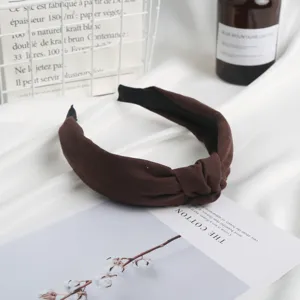Detail view of a brown suede knotted headband, soft daily hair accessory for women.