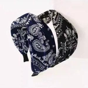 Retro wide fabric headband featuring classic paisley print, stylish knotted design.