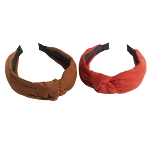 Two suede knotted headbands in brown and red colors, stylish hair accessories for daily wear.