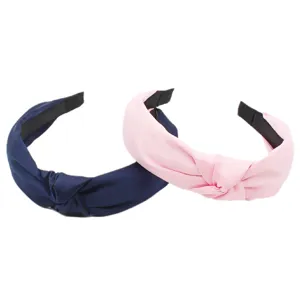 Detailansicht von handgefertigten, einfarbigen Stoff-Haarreifen in Dunkelblau und Rosa.