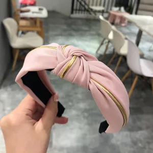Pink fabric headband with gold trim, stylish cross knot design for women daily hair accessory.