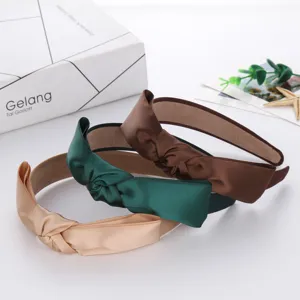 Detailed view of elegant satin knotted headbands in champagne, green and brown colors.