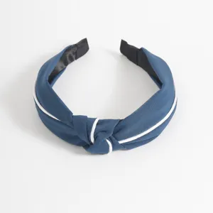 Close-up detail of the blue fabric headband with white piping and knot. Perfect hair accessory!