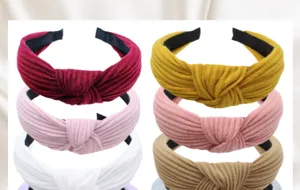 Detailed view of knitted wide cross headbands, soft fabric hair hoops in various colors.