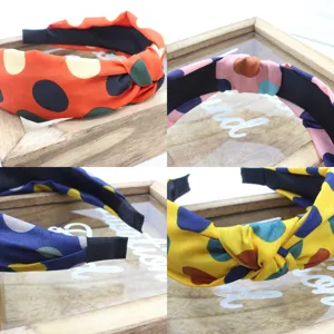 Detailed shot of Korean style fabric cross knotted polka dot headband in vibrant colors.