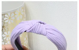 Detailed close-up view of the light purple ribbed knit headband with a stylish cross knot design.