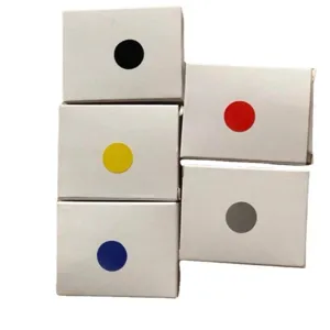 Vue détaillée des boîtes d'emballage blanches avec des étiquettes de points colorés.