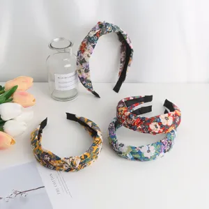 Detailed view of sweet floral knotted fabric hair headband, stylish everyday fashion accessory.