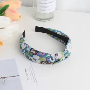 Detailed view of the blue floral knotted headband, showcasing soft fabric and cute design.