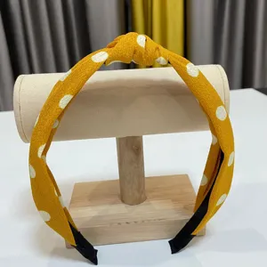 Yellow polka dot headband for women, stylish knotted wide brim hair hoop for daily wear.