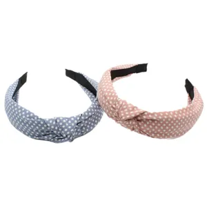 Close-up of stylish polka dot fabric knotted headband detail, soft texture and wide design.