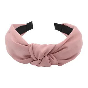 Detailed view of the solid pink knotted fabric headband, stylish wide hair hoop for daily wear.