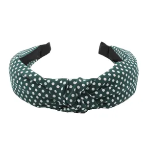 Detail view of a stylish green polka dot headband with knot design, fabric wide hair hoop.