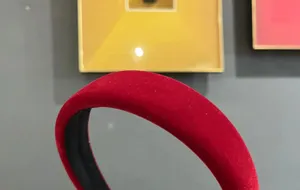 Detail view of a red velvet sponge headband, showing soft texture and high cranial top style.