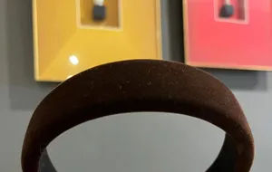 Close-up detail of brown velvet padded wide headband, showing soft texture and high top.