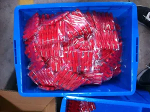 Valve core wrench tool with red plastic handle, packaged in bulk for tire repair work.