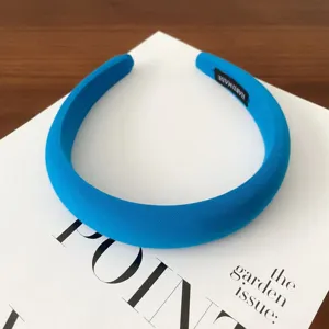 Detailed close-up view of the solid blue wide padded fabric headband and interior texture.