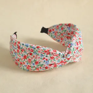 Detailed close-up view of the wide floral print knotted fabric hair hoop texture.