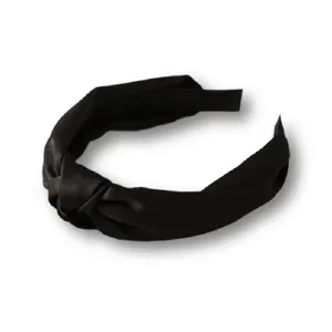 Black satin knotted headband detail shot showing smooth fabric texture and elegant twisted design.