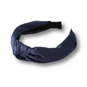 Close-up detail of the dark blue satin knotted headband showing the smooth fabric and wide design.