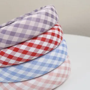 Gros plan sur les bandeaux rembourrés à carreaux mignons en violet, rouge, bleu et rose.