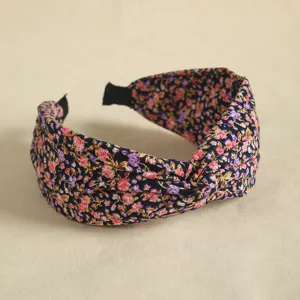 Detailed view of a trendy floral patterned knotted wide headband for women daily hair styling.