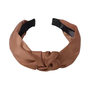 Brown satin knotted headband detail view, smooth fabric surface and neat sewing edges.
