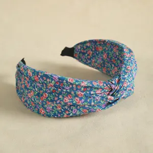 Close-up view of blue floral knotted headband, wide fabric hair hoop for daily wear.