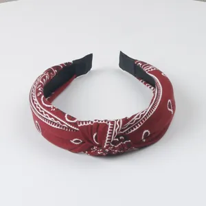 Gros-plan sur le bandeau en tissu paisley rouge avec nœud et belle texture douce.