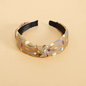 Gedetailleerde opname van retro stoffen haarband met bloemenprint en knoop, elegant.