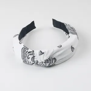 Vue détaillée du serre-tête noué cachemire noir et blanc, accessoire de coiffure élégant.