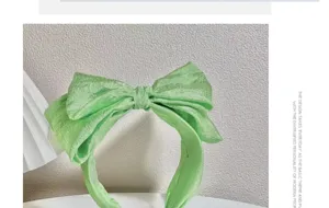 Close-up detail of the light green seersucker bow headband, featuring a wide brim and cute design.