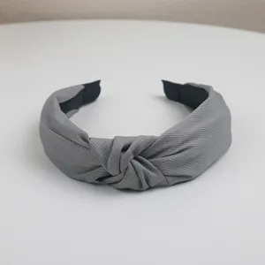 Close-up detail of the grey knotted fabric headband, minimalist wide hair hoop accessory.