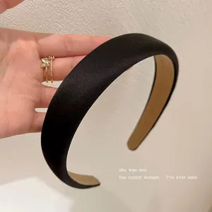 Nahaufnahme des breiten schwarzen Satin-Haarreifs, hohes Schädeldesign und glatte Textur.