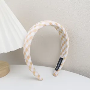 Gros plan detaille du magnifique serre-tete en tissu vichy jaune et blanc avec etiquette.